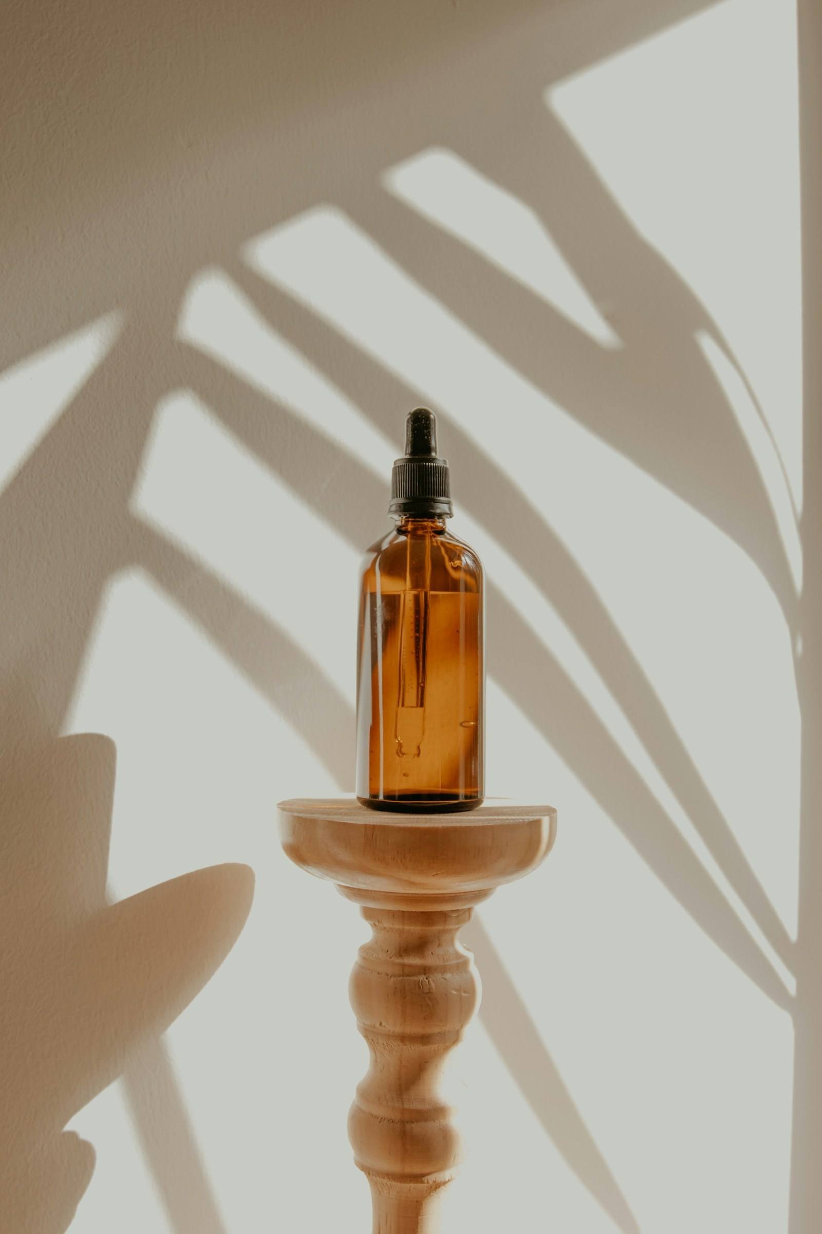 Braune Serumflasche im Schatten eines Blattes