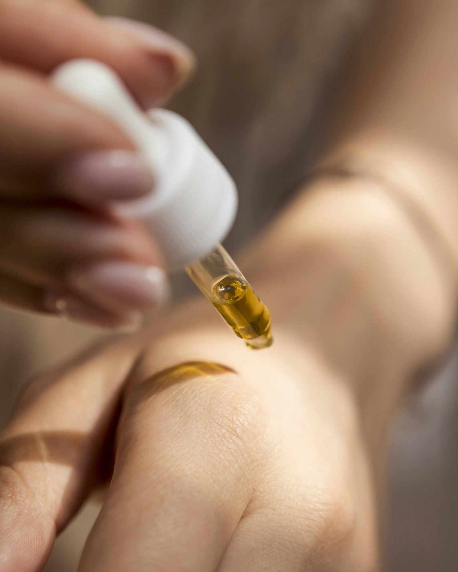Ein Tropfen Serum aus der Pipette auf der Haut