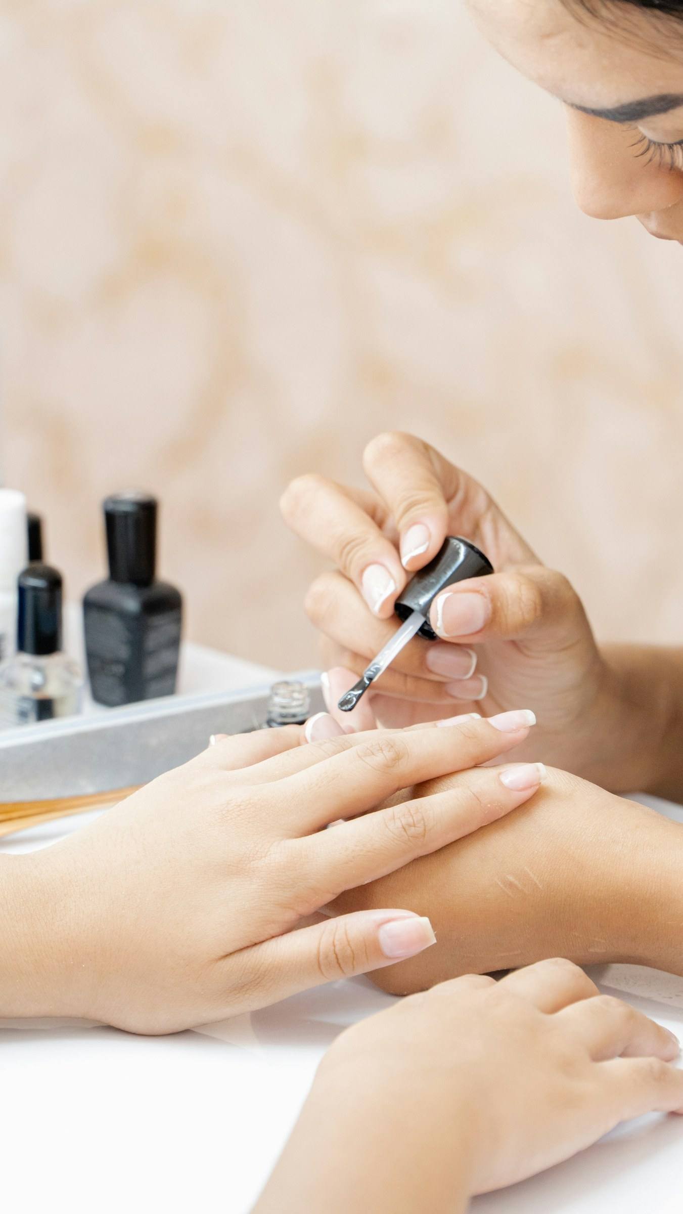Nagellack wird bei einer Maniküre sorgfältig aufgetragen